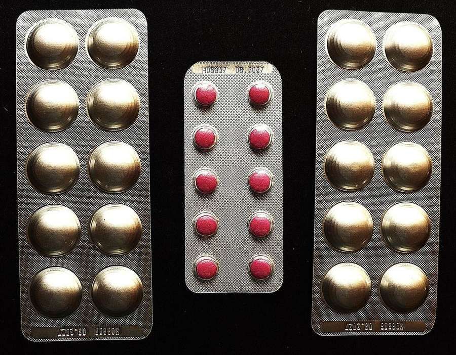 A foil blister pack of round white tablets.